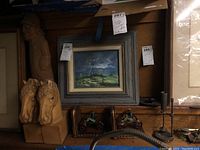 Photo showing carved wooden horse head bookends, ceramic figurine bookends, small framed landscape painting with tags visible