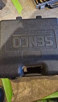 Closed black molded plastic case with Senco embossed branding on top surface.