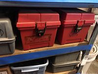 Shelving unit with red welding supply boxes labeled 'Welding' and 'Weld' alongside gray and black boxes