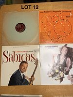 Four vintage record albums displayed including Sabicas, Andres Segovia, Howard Roberts, and one open record sleeve with His Master's Voice Victor 78 RPM record.
