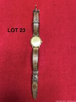 Full view of gold-tone Eterna watch on red background