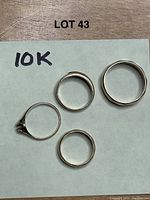Five rings arranged on paper marked “10K” under lot number.