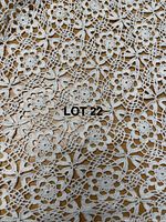 Close-up photo showing detailed floral crochet lace pattern of the large handmade tablecloth, highlighting the fine cotton craftsmanship.