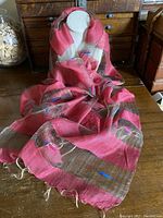Full view of lightweight silk scarf draped on display showing fuchsia and coffee horizontal stripes with fringe edges