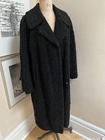 Full front view of black textured coat on mannequin