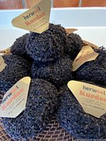 Close-up of 10 balls of Herwool Kurdan yarn showing nubbly texture and color blend.