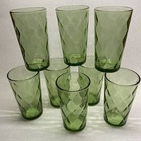 Eight apple green glass tumblers arranged in two rows, showing diamond texture pattern and uniform color.