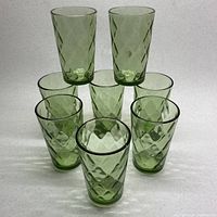 Set of 8 apple green textured glasses arranged with two glasses elevated on top forming a pyramid shape, showing color and texture.
