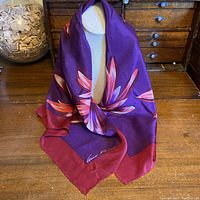 Full view of scarf draped over a mannequin torso to show size, colors and floral pattern.