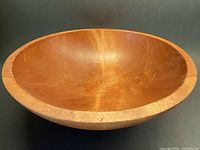 Front view of the large solid maple wooden bowl showing inner wood grain and overall shape.