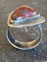 Side angle showing the triangular bezel setting with carnelian stone and silver band.