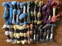 Full lot of 46 skeins of tapestry yarn laid out showing variety of colors and black labels