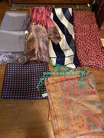 Top view of all six scarves laid out on a wooden surface showing different colors and patterns.