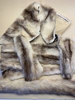 Photo showing soft grey and white mink pelts, one shaped with sleeves or parts sewn to maintain form.