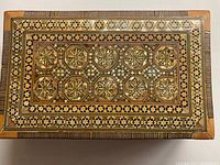 Top view showing intricate geometric inlay and intact mother of pearl pieces.