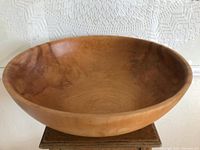 Side view showing the smooth curvature and wood grain of the bowl.