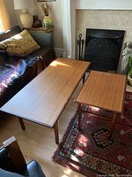 Pair of teak tables with walnut frames shown in living room