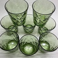 Top-down and partially side view showing the muted diamond texture and green color of the eight lowball glasses arranged in a circle.