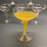 One champagne bowl filled with liquid showing shape and size, with 5 others behind it.