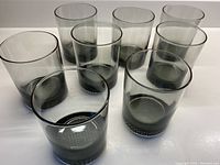 Set of eight smokey grey tubular glasses showing shape, color, and condition.