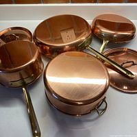 Four pieces upside down showing copper bases and brass handles
