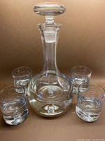 Full set showing decanter with stopper and four matching glasses with bubble bottoms.