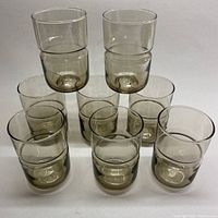 Full view of all 8 smokey grey glasses arranged in two rows showing uniform size and color.
