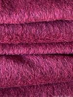 Close-up of the fabric showing the texture and fine short pile fibers in dark burgundy color.