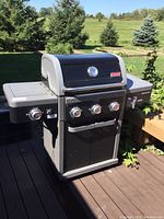 Front three-quarter view of grill on deck with scenic background