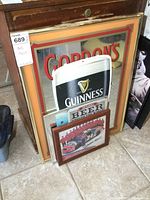 Framed Gordon's beer mirror with Guinness and Jeff Gordon sign in front