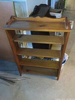 Front view of solid pine bookshelf showing four shelves and top decorative scalloped edges.