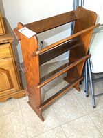 Front and side views of the vintage solid wood bookcase showing three slanted shelves and wood panel sides with curved detail.