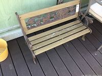 Front and side view of child's bench showing cast iron ends and wood slatted seat with carved animal wood panel inset on the backrest.
