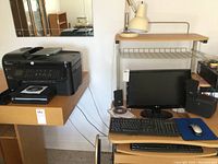 Overview photo showing all items in the lot on and around desks including monitor, printer, keyboards, mouse, speakers, and desk lamp