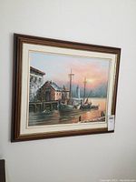 Photo showing full framed painting on wall, harbor scene with boats and lighthouse at sunset.
