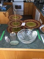 Overall view of the set on kitchen counter showing the glass pedestal cake plate, three-tiered serving dish, salt and pepper shakers, jar, and serving bowl