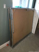 Disassembled ping pong table halves showing the underside with metal frame and folding legs folded in.