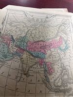 Close-up photo of a historic colored map showing Asia with regions like the Central Chinese Empire, Bengal, and surrounding areas, revealing paper texture and age wear.