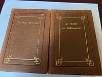Two leather bound books with gold printed titles: De tout son âme and Le guide de l'empereur.
