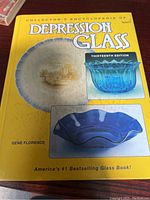 Front cover of the book showing the title, author, and images of depression glass bowls and plates in blue and amber.