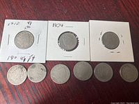 Top row of 3 dimes in holders and 6 loose dimes below on a wood surface.