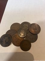 Nine French Napoleon III coins arranged on a white surface, visible worn faces with Napoleon III profile and eagle on reverse.