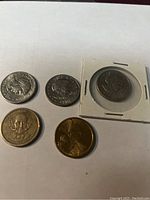 5 US dollar coins including Susan B Anthony, President Van Buren, and Sacagawea coins displayed on white background. One coin in protective holder.