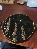 Full view of the black amethyst two-handled octagonal platter showing hand-painted floral designs and gold trim on a dark glass base.