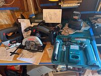 Photo showing Craftsman power tools including jig saw, trim saw, circular saw, corner sander, hand vacuum, and various manuals on a workbench.