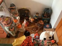 View of entire group of Halloween and fall-themed decor including scarecrows, ghosts, pumpkin decorations, lantern, wall art, and Lucy Goosey clothing.