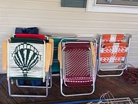 Group view of folded lawn and canvas bag style chairs on porch