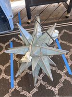 Top view of the Moravian star light showing the leaded glass points and attached hanging hook and cord.