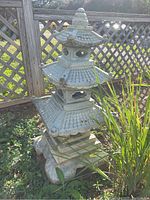 Full view of three-tiered pagoda ornament in garden setting