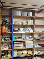 Shelves filled with vintage plastic storage containers, mixing bowls, and various kitchenware items.
